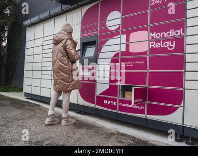 Loriol sur Drome, Frankreich - 14. Januar 2023: Abholung eines Pakets aus einem Mondial`Relay-Schließfach durch eine junge Frau. Schließfächer Mondial Relay. Pickup-Box. Stockfoto